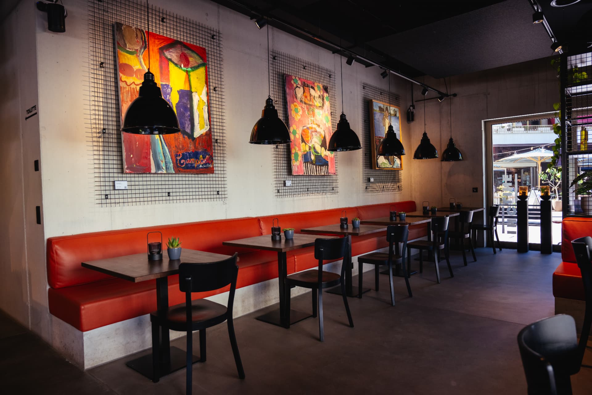 Rote Sitzbank und Tische im Incline Concept Store